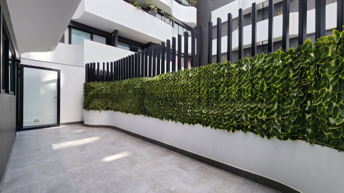 Terraza privada del departamento con muro verde
